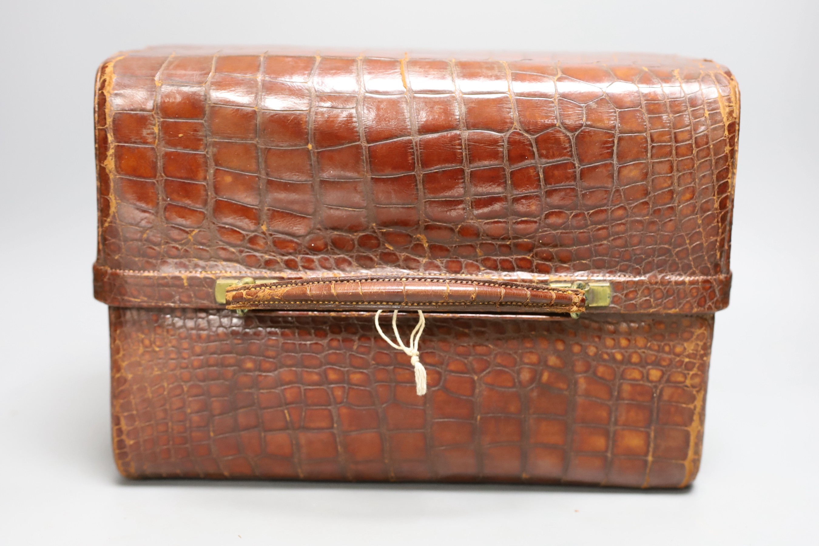 An early 20th century crocodile three tier travelling jewellery bag with key (lock a.f.) - 30cm long